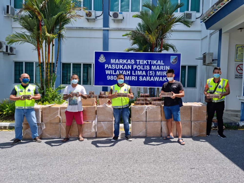 The raiding team with the two suspects (second and fourth left) and the seized contraband. u00e2u20acu201d Borneo Post Online pic