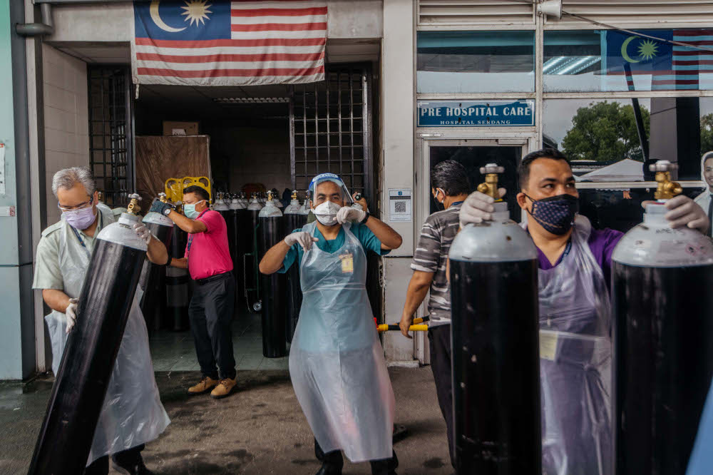 Workers arrange medical oxygen cylinders to be sent to the Covid-19 Low-Risk Quarantine and Treatment Centre (PKRC) at the Malaysia Agriculture Expo Park (MAEPS) at Hospital Serdang July 26, 2021. u00e2u20acu201d Picture by Shafwan Zaidon