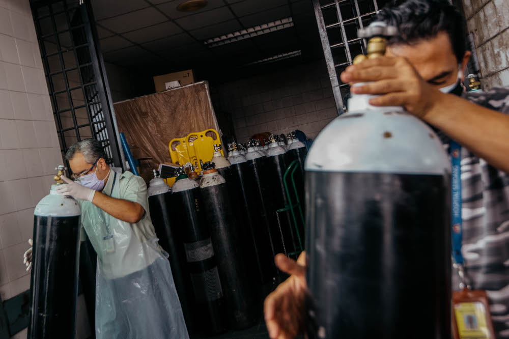 Workers arrange medical oxygen cylinders to be sent to the Covid-19 Low-Risk Quarantine and Treatment Centre (PKRC) at the Malaysia Agriculture Expo Park (MAEPS) at Hospital Serdang July 26, 2021. u00e2u20acu201d Picture by Shafwan Zaidon