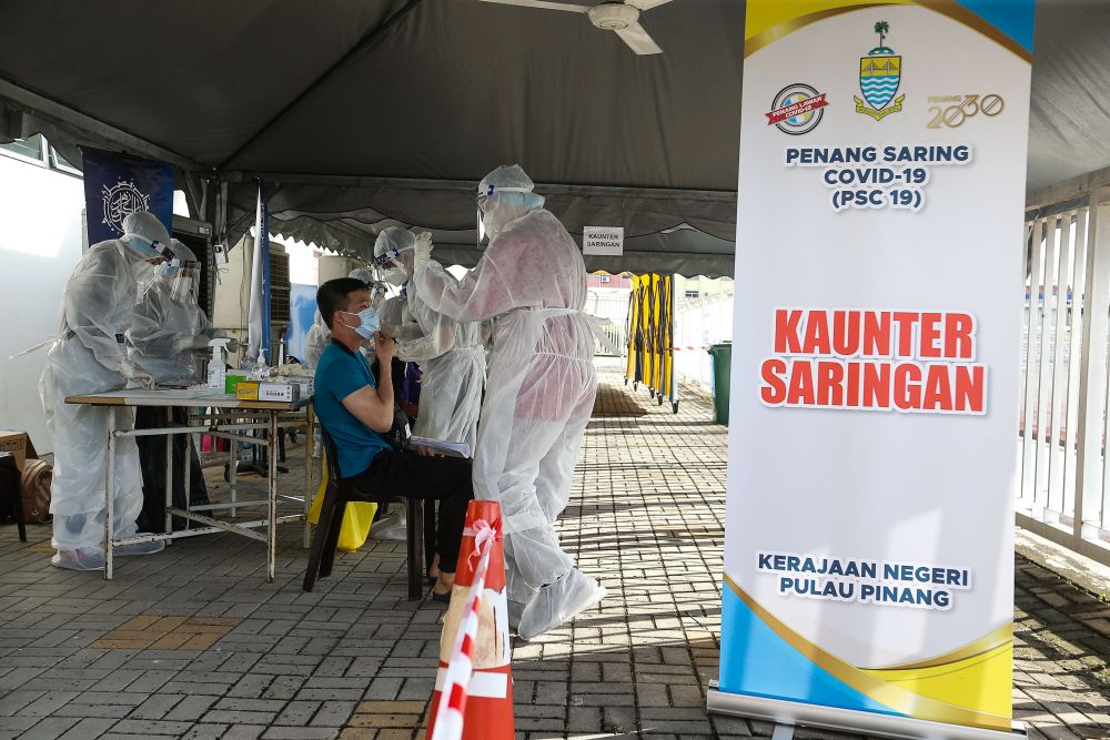 Healthcare workers collect swab samples to test for Covid-19 at the City Stadium in George Town July 5, 2021. u00e2u20acu201d Picture by Sayuti Zainudin