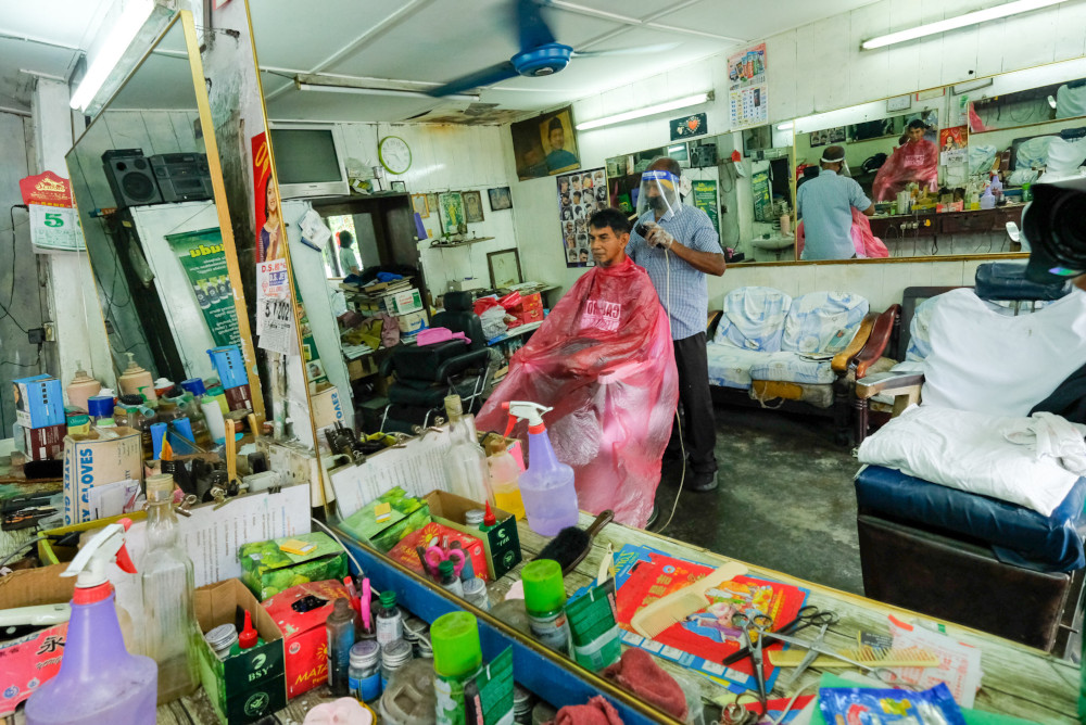 Gnasegaran Rammaya, 70, cutting the hair of a customer at his shop Kedai Gunting Rambut Kampong Kepayang in Ipoh, July 5, 2021. u00e2u20acu201d Picture by Farhan Najibn