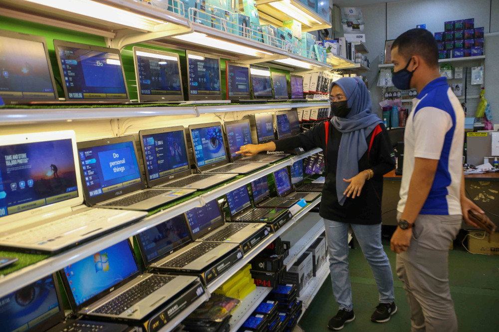 A sales assistant attends to a customer at the Mytec Computer in Station 18, Pengkalan in Ipoh. — Picture by Farhan Najib