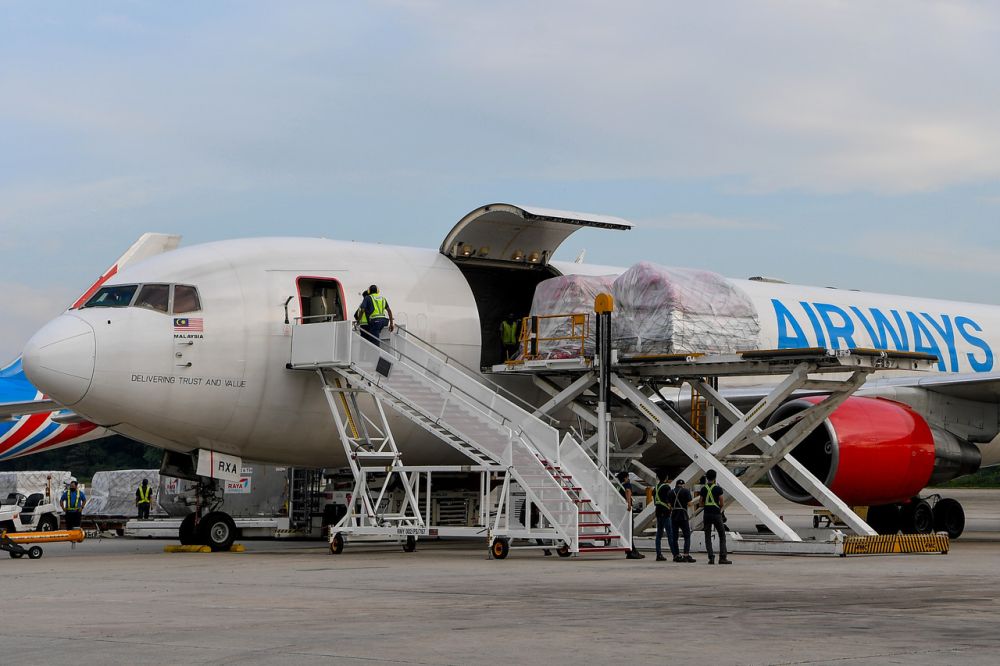 Workers unload Pfizer Covid-19 vaccines donated by the US at the Sultan Abdul Azis Shah Airport in Subang July 5, 2021. u00e2u20acu201d Bernama pic
