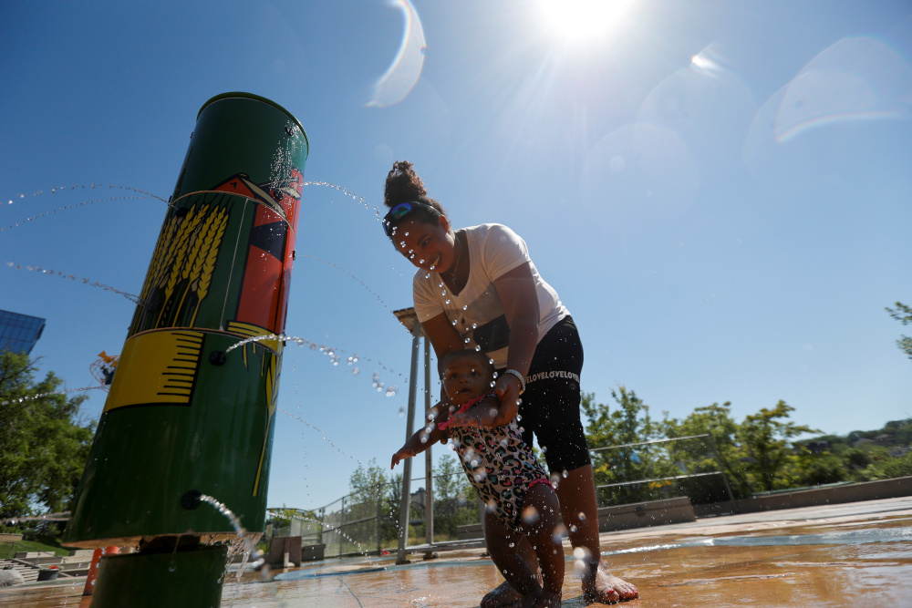 Rahel Kidne and her daughter Eliana play in water to cool off during the scorching weather of a heatwave, at a River Landing splash park in Saskatoon, Saskatchewan July 2, 2021. u00e2u20acu201d Reuters pic