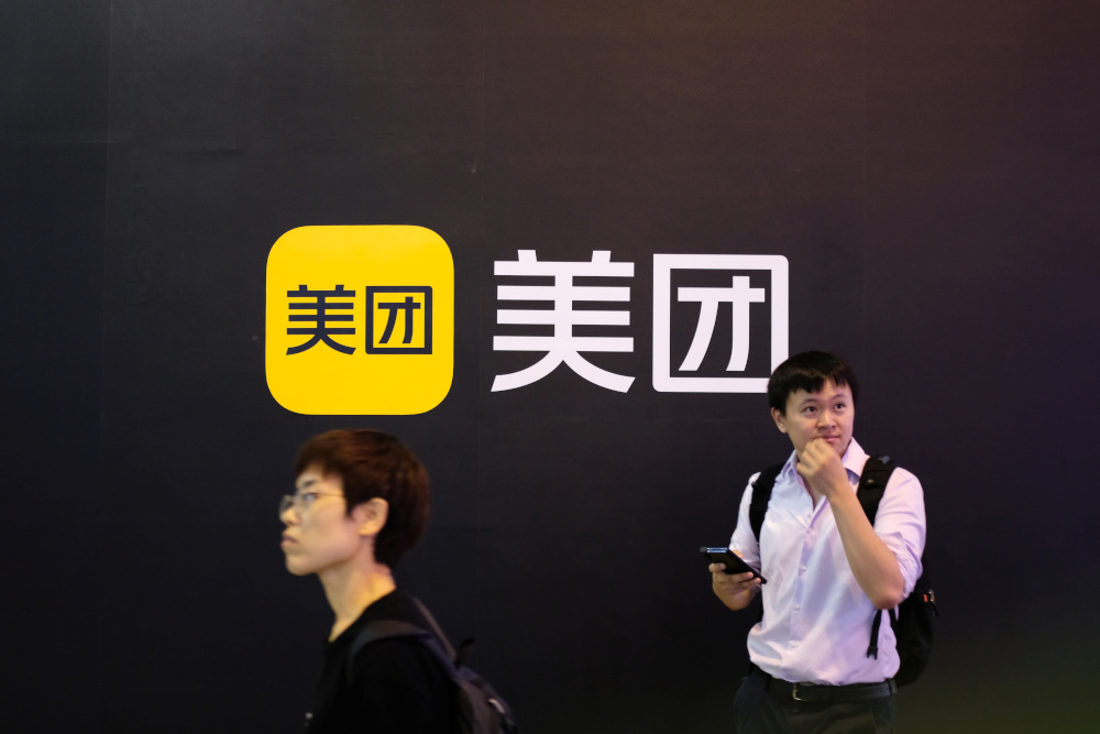 People walk past a Meituan logo at the World Artificial Intelligence Conference (WAIC) in Shanghai July 8, 2021. u00e2u20acu201d Reuters pic