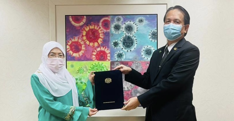 Health director-general Tan Sri Dr Noor Hisham Abdullah presenting the appointment letter to Dr Rose Nani Mudin. u00e2u20acu2022 Borneo Post pic