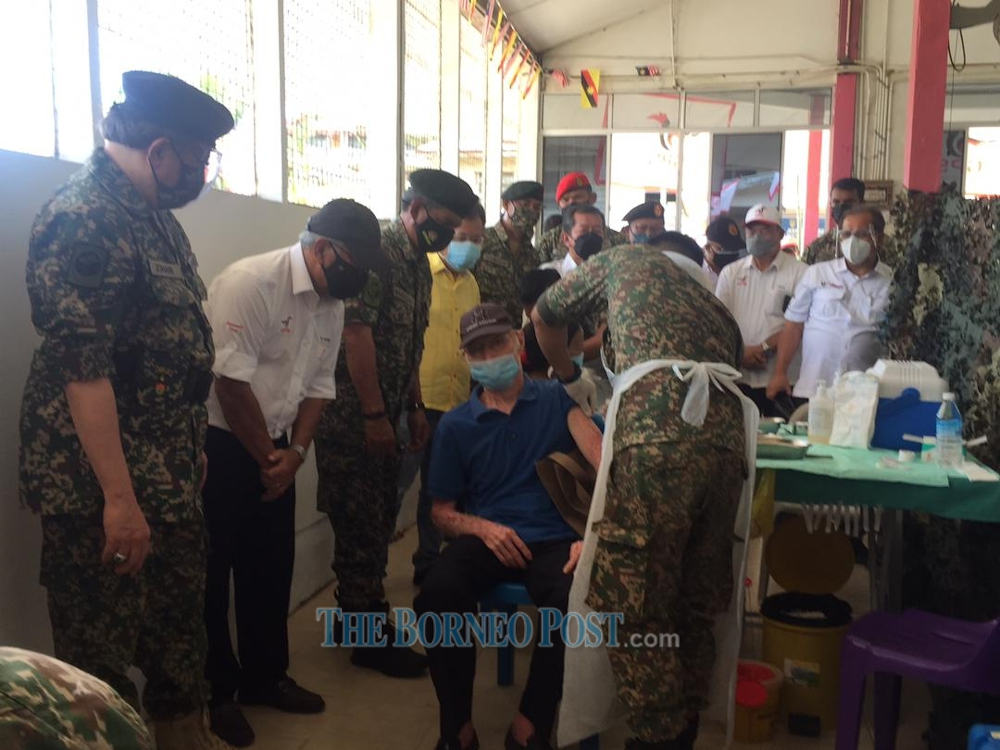 Datuk Patinggi Abang Johari Openg (left), Tan Sri James Jemut Masing (2nd left) and others watching a recipient getting his second jab at Nanga Jagau July 31, 2021. u00e2u20acu201d Borneo Post pic