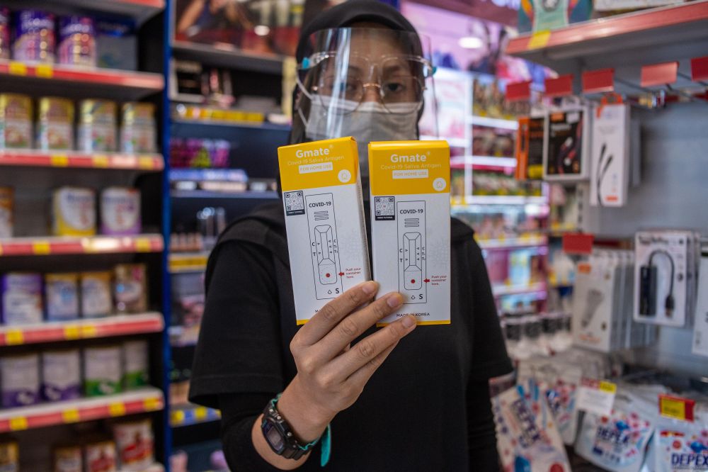 A pharmacy staff holds up Gmate Covid-19 rapid antigen self-test kits in Subang Jaya July 28, 2021. u00e2u20acu201d Picture by Shafwan Zaidon