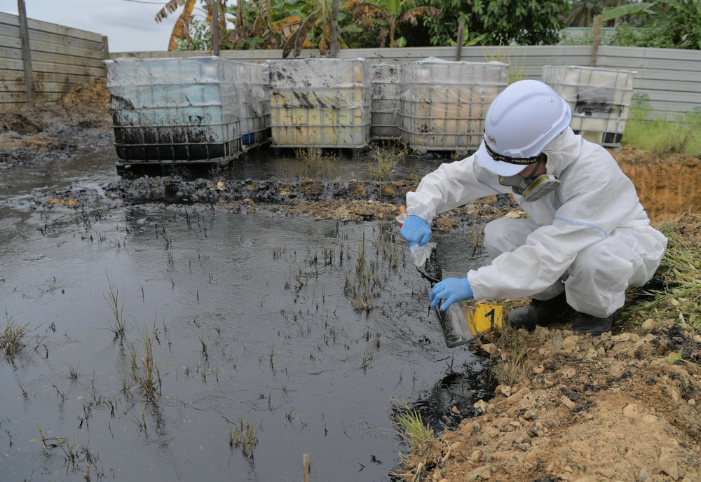 A Johor Department of Environment officer takes a sample of the chemical that flowed into Sungai Sengkang in Kulai, July 4, 2021. u00e2u20acu201d Bernama pic 