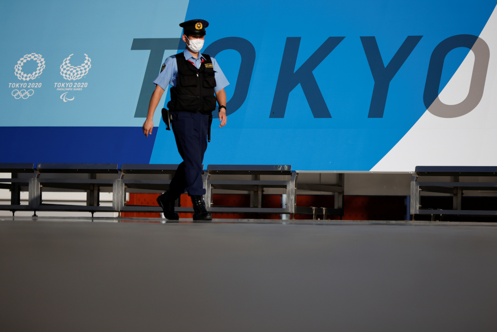 A police officer wearing a face mask walks past Tokyo 2020 Olympic Games signage at the Main Press Centre in Tokyo, Japan, July 16, 2021. u00e2u20acu201d Reuters pic 