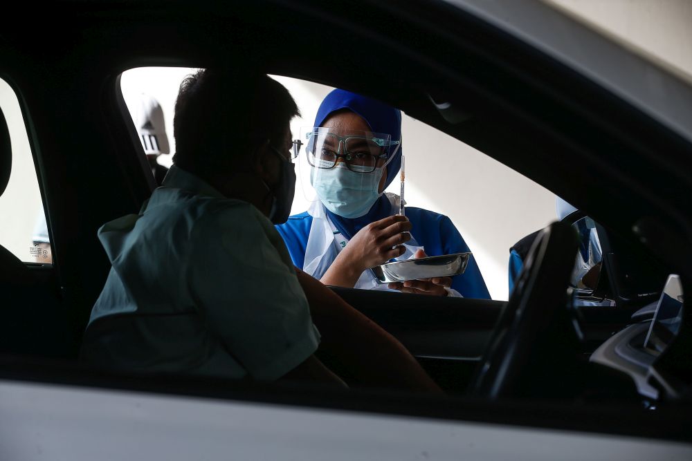 A man waits to receive his Covid-19 jab at Universiti Sains Malaysia’s drive-through vaccination centre in Penang July 23, 2021. — Picture by Sayuti Zainudin