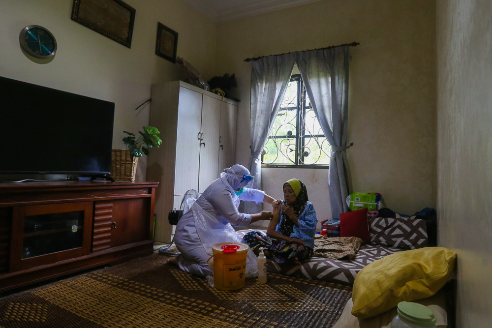 A senior citizen gets her Covid-19 jab at home in Sabak Bernam during the vaccination outreach programme for the elderly and disabled administered by the Sabak Bernam District Health Office, July 13, 2021. u00e2u20acu201d Picture by Yusof Mat Isa