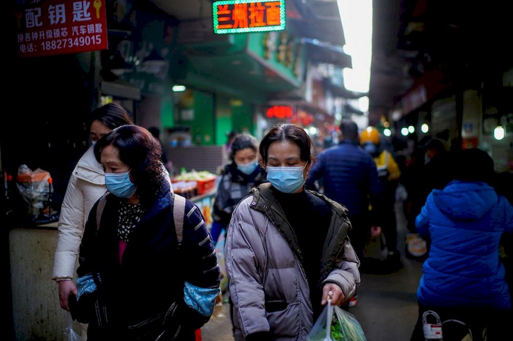 People wearing face masks walk on a street market, following an outbreak of the coronavirus disease (Covid-19) in Wuhan, Hubei province, China February 8, 2021. u00e2u20acu201d Reuters pic