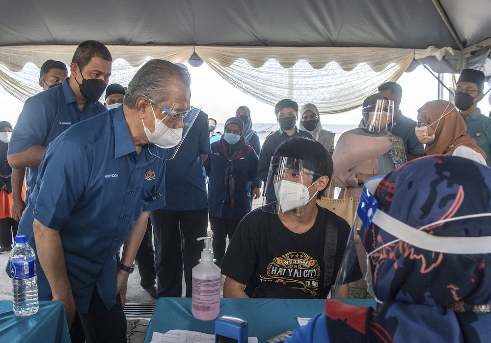Prime Minister Tan Sri Muhyiddin Yassin chatting with vaccine recipients during his visit to the Vaccination Center at Dataran Felda Batu 27 Pagoh August 6, 2021. u00e2u20acu201d Bernama pic