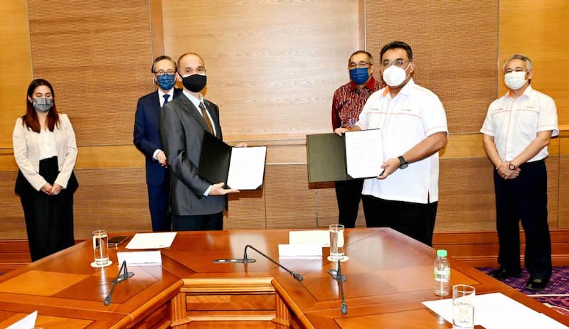 Masidi and Salleh witness the exchange of the Supply and Distribution Agreement. u00e2u20acu201d Borneo Post pic