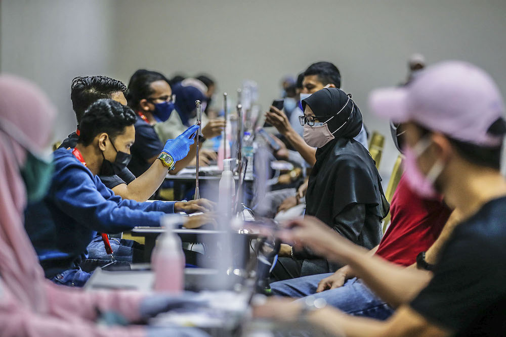 Members of the public get ready to receive their Covid-19 vaccination at the vaccination centre (PPV) in Kuala Lumpur Convention Center August 8, 2021. u00e2u20acu2022 Picture by Hari Anggara