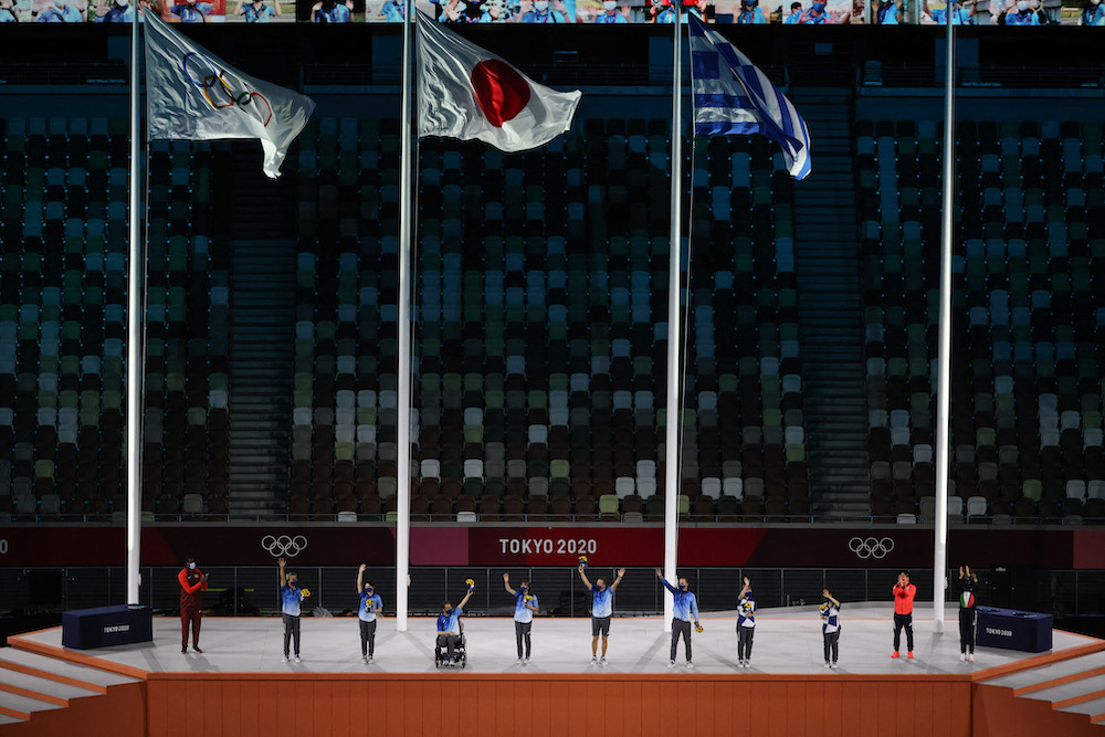 Volunteers acknowledge applause on stage during a ceremony of recognition of the Tokyo 2020 Olympics' volunteers, during the closing ceremony of the Tokyo 2020 Olympic Games, on August 8, 2021 at the Olympic Stadium in Tokyo. u00e2u20acu201d AFP pic