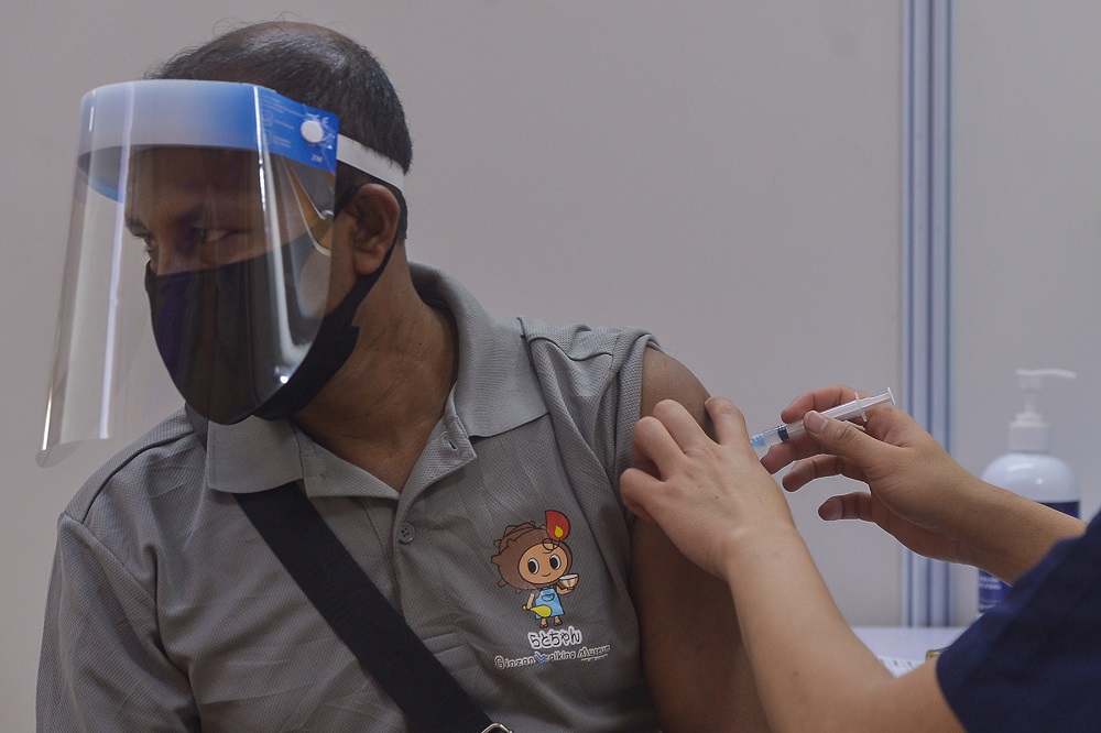 A foreign worker receives his Covid-19 vaccination at Komplek Sukan PKNS in Kelana Jaya August 10, 2021. u00e2u20acu201d Picture by Miera Zulyana