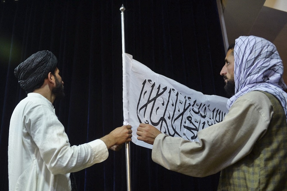 Men adjust the Taliban flag before the arrival of Taliban spokesperson Zabihullah Mujahid (unseen) to address the first press conference in Kabul August 17, 2021. u00e2u20acu201d AFP pic 