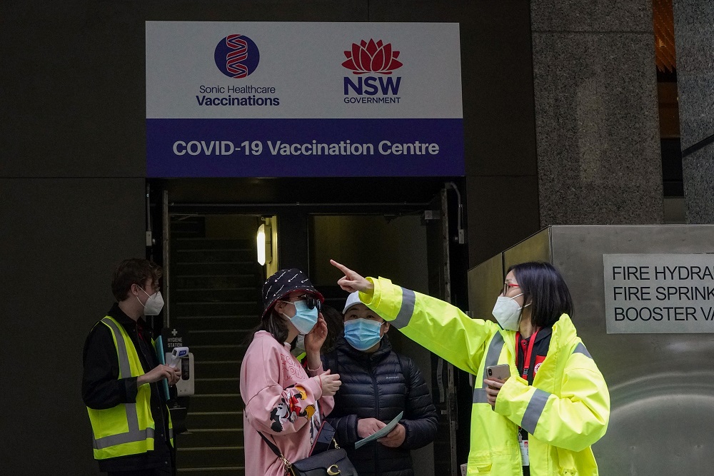 A staff member speaks with people at the entrance to a vaccination centre in Sydney, Australia August 18, 2021. u00e2u20acu2022 Reuters pic