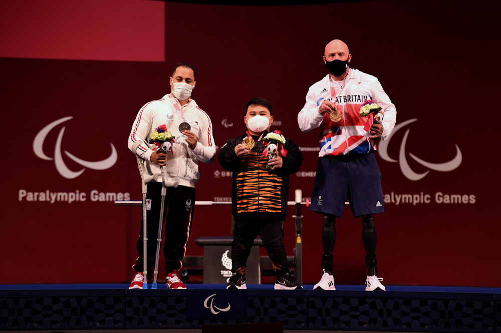 National paralympic powerlifting athlete Bonnie Bunyau Gustin (centre) poses with Egyptu00e2u20acu2122s Attia Mahmoud (left) and Britainu00e2u20acu2122s Yule Micky after winning the gold medal in the 72kg category at the Tokyo 2020 Paralympic Games August 28, 2021. u00e2u20acu201d Bernama p