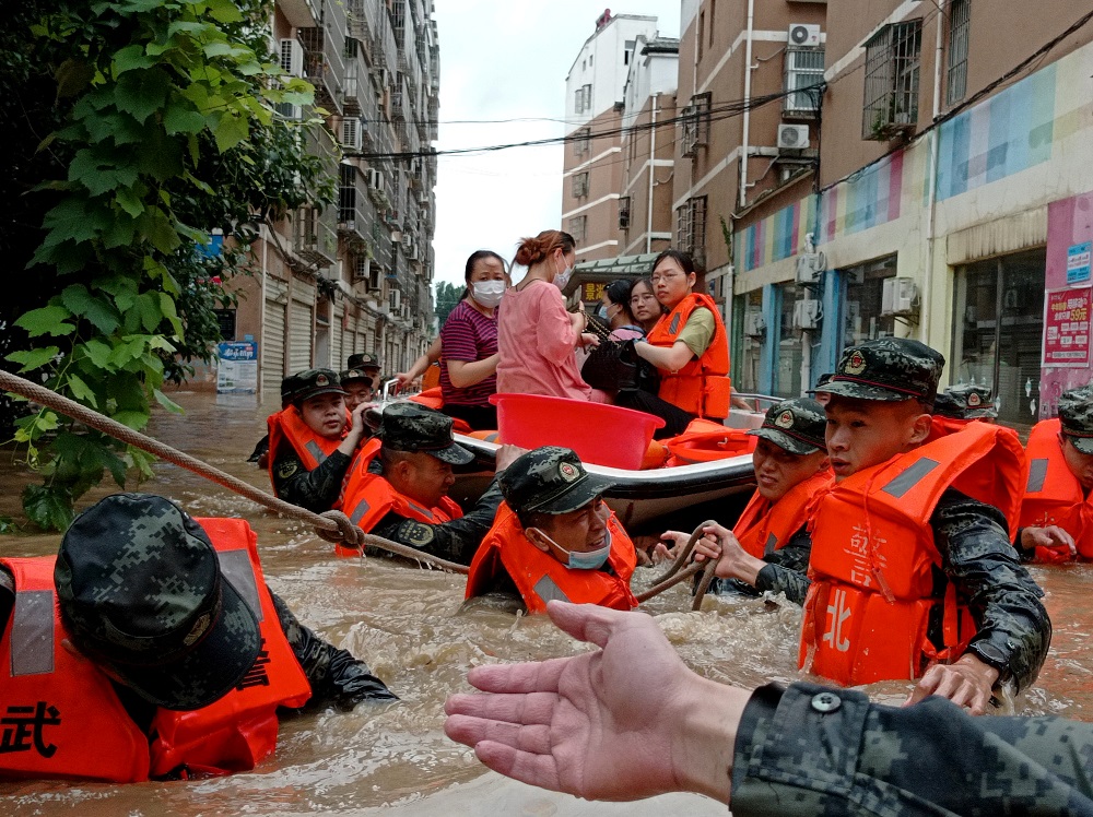 Paramilitary police officers evacuate residents stranded by floodwaters with a boat following heavy rainfall in Hedian town of Suizhou, Hubei province, China August 12, 2021. u00e2u20acu2022 cnsphoto via Reuters