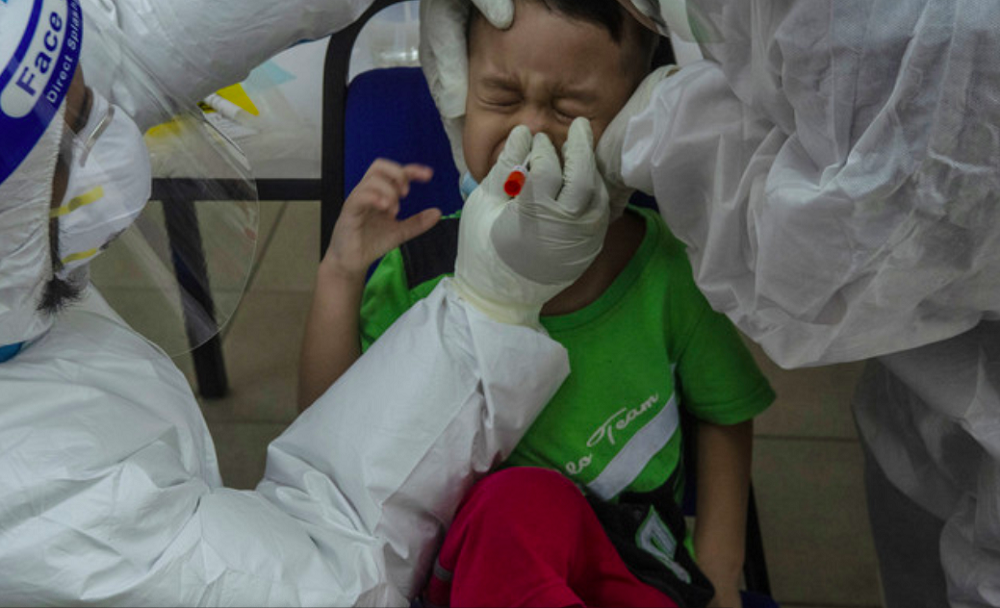 A child reacts as a health worker takes a nasal swab for Covid-19 testing. u00e2u20acu201d Bernama pic