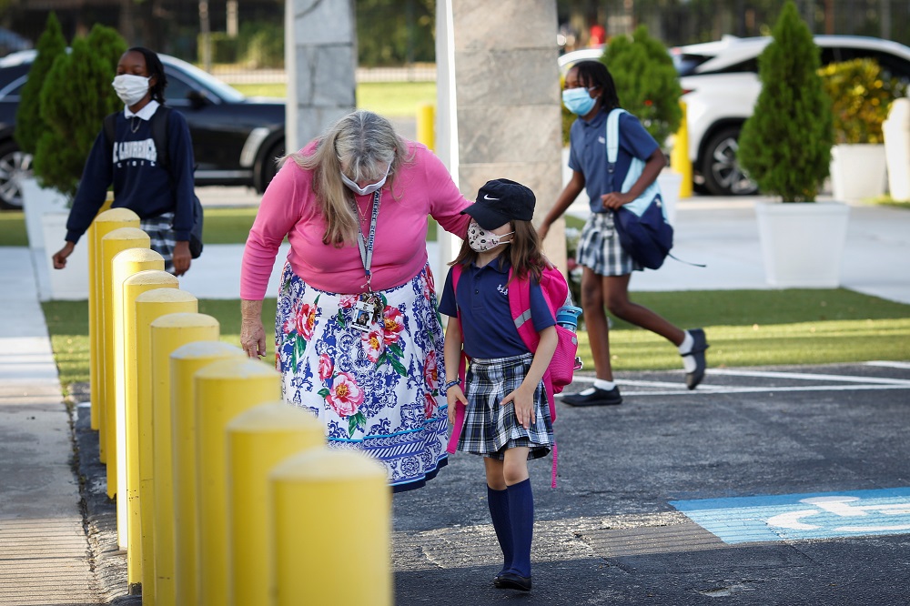 Dian Hyatt, Principal of St. Lawrence Catholic School, welcomes a student, as they wear protective masks on the first day of school in North Miami Beach, Florida August 18, 2021. u00e2u20acu2022 Reuters pic