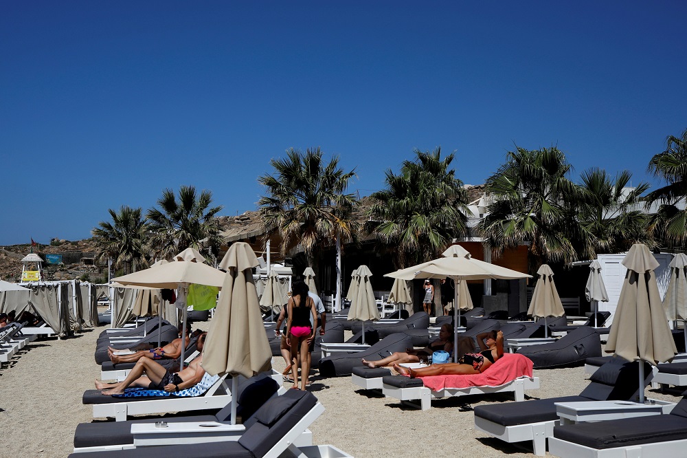 People lay on sunbeds at the Tropicana beach bar in Paradise beach on the island of Mykonos, Greece July 18, 2021. u00e2u20acu2022 Reuters file pic