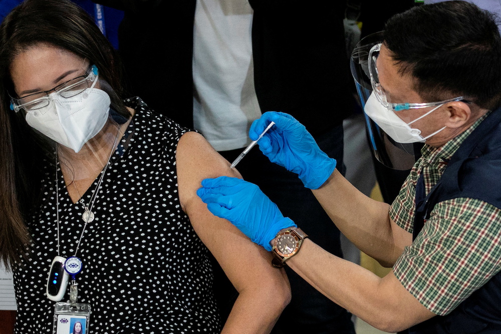Philippinesu00e2u20acu2122 Health Secretary Francisco Duque vaccinates a health worker with Sinovac Biotechu00e2u20acu2122s Coronavac on the first day of the Covid-19 inoculation drive in the Philippines, at the Lung Centre of the Philippines, Quezon City, Metro Manila, March 1,