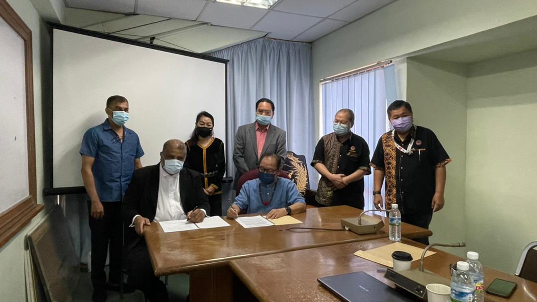 Marcel Jude Joseph (seated left) and KDCA deputy president Datuk Seri Jeffrey Kitingan (seated right) signing off on the settlement at the Penampang Native Court today.