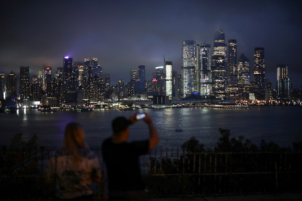 People watch clouds pass over middle Manhattan as Tropical Storm Henri passes through New York City, as seen from Weehawkenu00e2u20acu2122s Hamilton Park in New Jersey, US, August 18, 2021. u00e2u20acu2022 Reuters pic