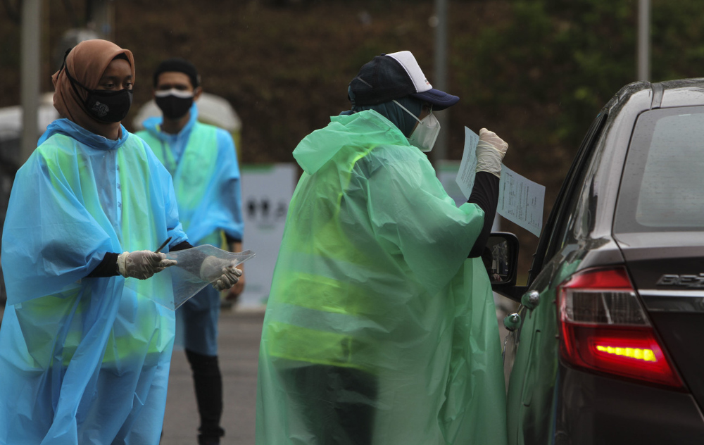 Volunteers check the QR code of Covid-19 vaccine recipients at the OKU Sentral drive-through vaccination centre in Johor Baru, August 25, 2021. u00e2u20acu2022 Bernama pic 