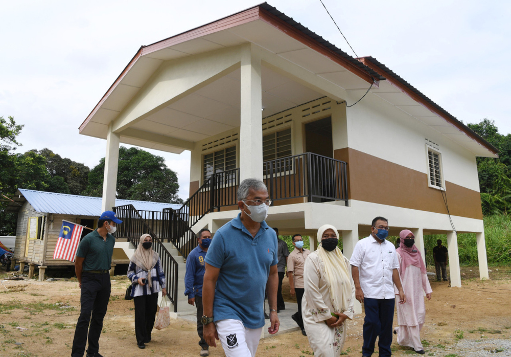 The King and the Regent of Pahang (left) survey a house donated to Norhasnah Md Yunos (3rd right) in Kampung Sungai Gangchong, Pahang, August 25, 2021. u00e2u20acu201d Bernama pic 