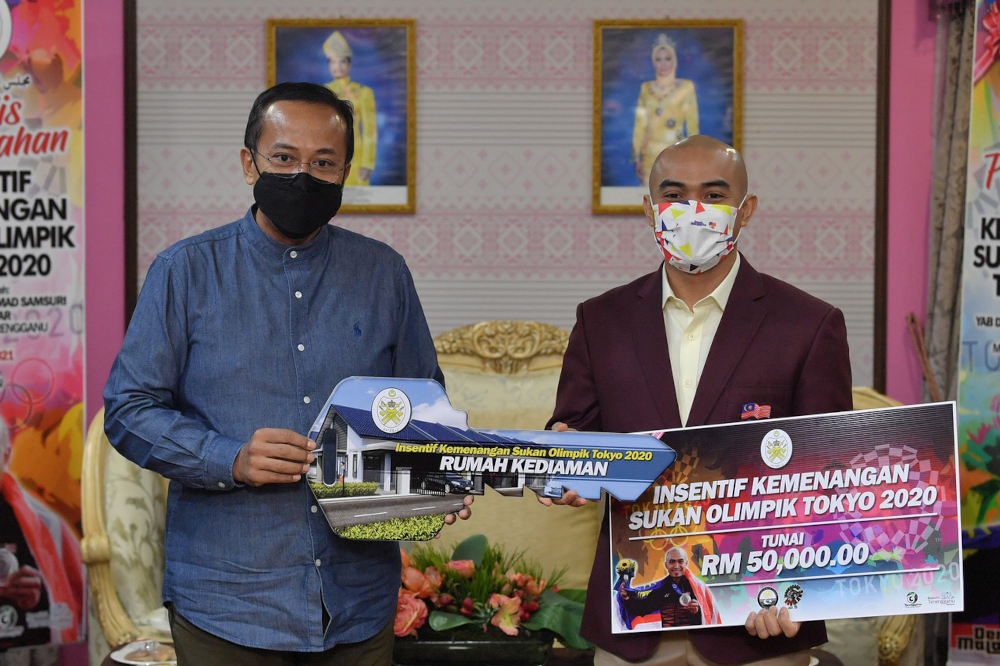 Mentri Besar Datuk Seri Ahmad Samsuri Mokhtar hands over the incentives to Datuk Azizulhasni Awang incentives at the Seri Iman Residence in Kuala Terengganu, August 25, 2021. u00e2u20acu201d Bernama pic 