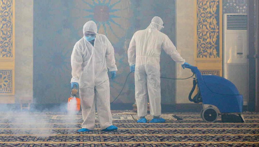 Workers wearing protective suits spray disinfectant at Suri Seri Begawan Raja Pengiran Anak Damit Mosque in an effort to counter the spread of the Covid-19 coronavirus in Bandar Seri Begawan in Brunei on 17 March, 2020. u00e2u20acu201d AFP pic