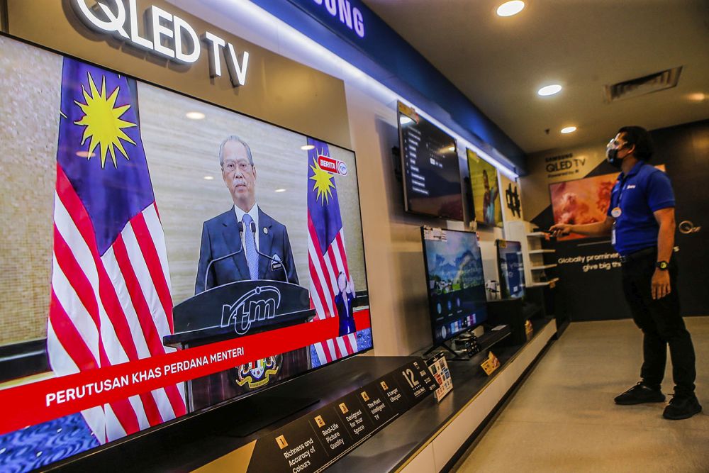 A live telecast of caretaker Prime Minister Tan Sri Muhyiddin Yassinu00e2u20acu2122s speech is played on TV screens at a Courts Mammoth store August 16, 2021. u00e2u20acu201d Picture by Hari Anggara