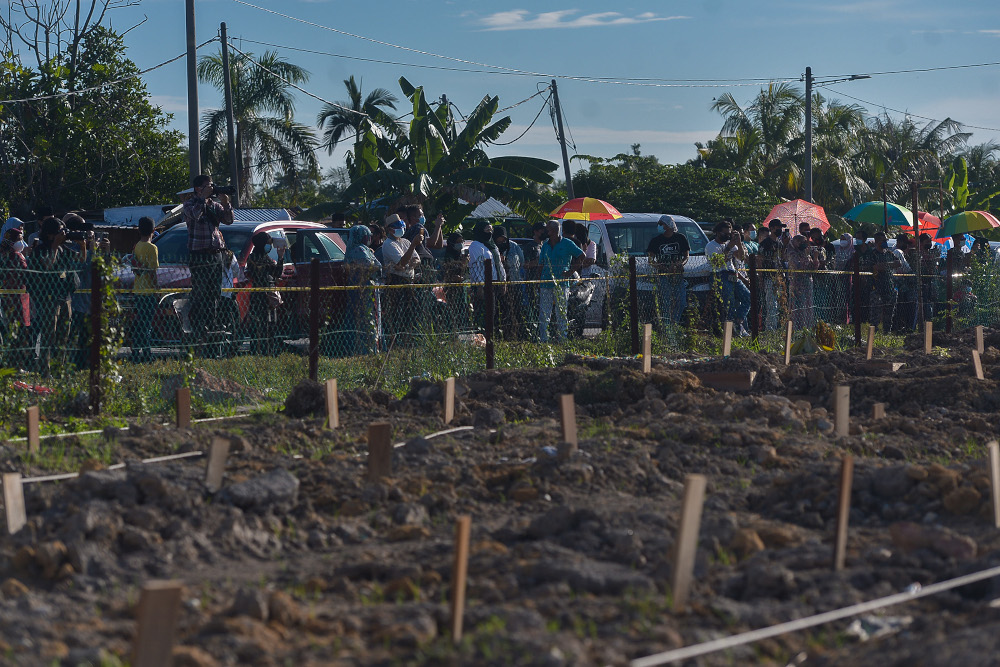 Family members of Covid 19 victims were only able to see the funeral of their loved one from outside the fence at the Islamic cemetery in Klang August 6, 2021. u00e2u20acu2022 Picture by Miera Zulyana