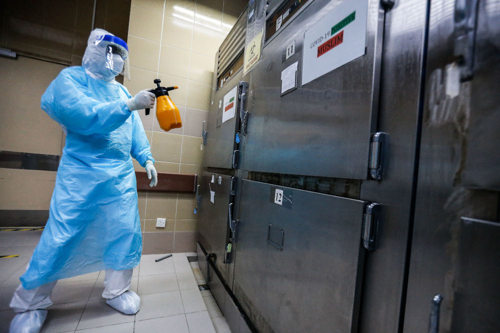 A forensics personnel conducts 'last office' procedure for a recently deceased Covid-19 patient at the Penang General Hospital, August 24, 2021. u00e2u20acu201d Picture by Sayuti Zainudin