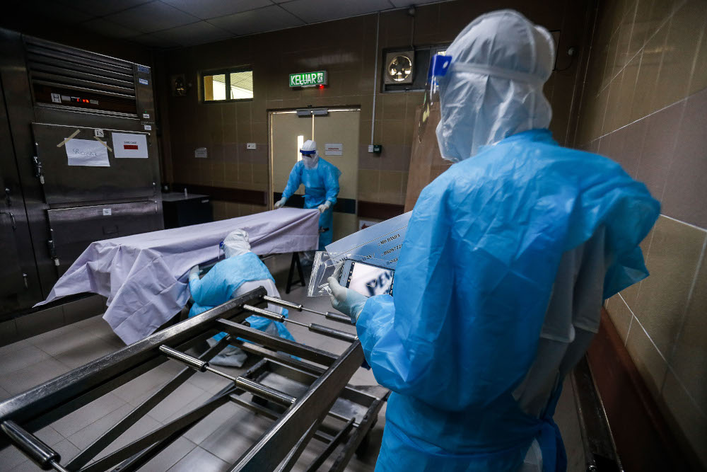 Forensics personnel prepare the body of a recently deceased Covid-19 patient for identification before burial at the Penang General Hospital, August 24, 2021. u00e2u20acu201d Picture by Sayuti Zainudin