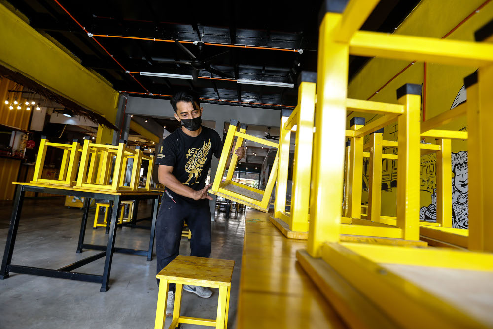 Shamsul Munir Safini, 37 pictured cleaning up the area as he prepares to receive dine-in customers at Lomaq Coffee, Seberang Jaya, August 9, 2021. u00e2u20acu201d Picture by Sayuti Zainudin