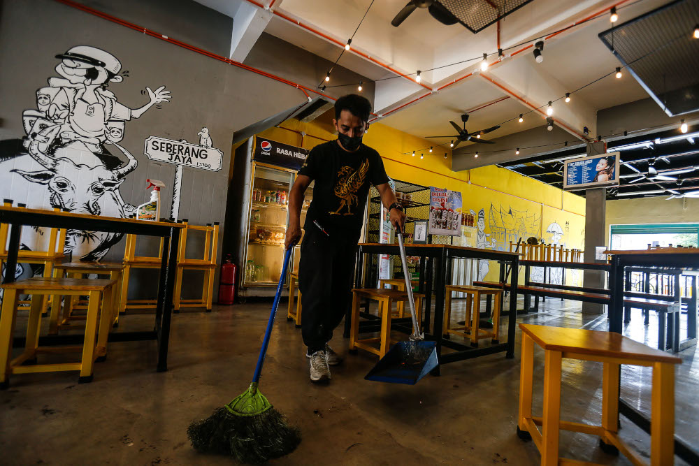 Shamsul Munir Safini, 37 is pictured cleaning up the cafe as he prepares to receive dine-in customers at Lomaq Coffee, Seberang Jaya, August 9, 2021. — Picture by Sayuti Zainudin