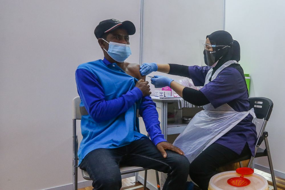 A foreign worker receives his Covid-19 jab during the Selangor Vaccination Programme at Pusat Kompleks Sukan PKNS in Kelana Jaya August 11, 2021. u00e2u20acu2022 Picture by Yusof Mat Isa