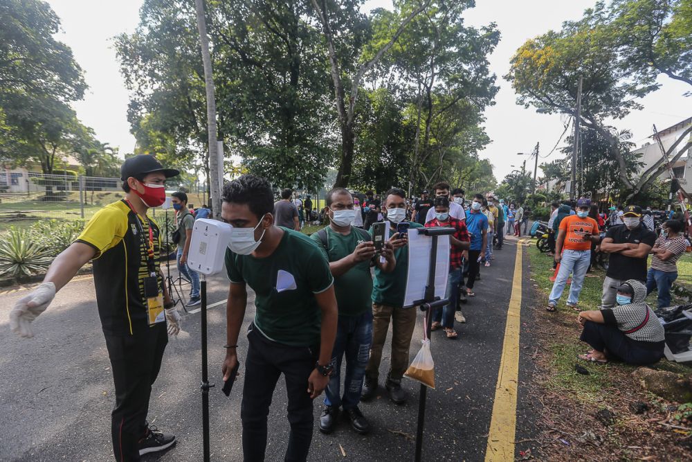 Foreign workers get their temperatures checked during the Selangor Vaccination Programme at Pusat Kompleks Sukan PKNS in Kelana Jaya August 11, 2021. u00e2u20acu2022 Picture by Yusof Mat Isa