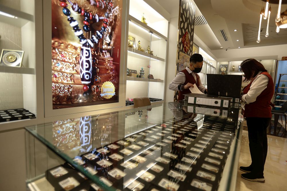 Workers at an accessory shop  get ready to reopen their premises to shoppers at the Gurney Paragon Mall, George Town August 18, 2021. u00e2u20acu2022 Picture by Sayuti Zainudin