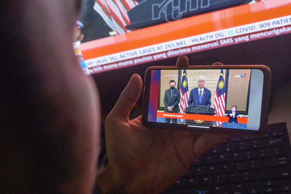 A man watches a live telecast of Prime Minister Datuk Seri Ismail Sabri Yaakobu00e2u20acu2122s speech in Kuala Lumpur August 27, 2021. u00e2u20acu201d Picture by Miera Zulyana