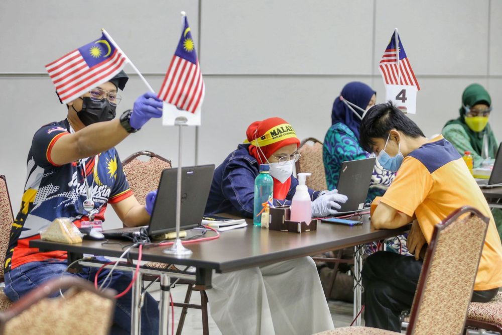 Malaysian flags are seen at the KLCC Covid-19 vaccination centre on National Day August 31, 2021. u00e2u20acu201d Picture by Ahmad Zamzahurinn