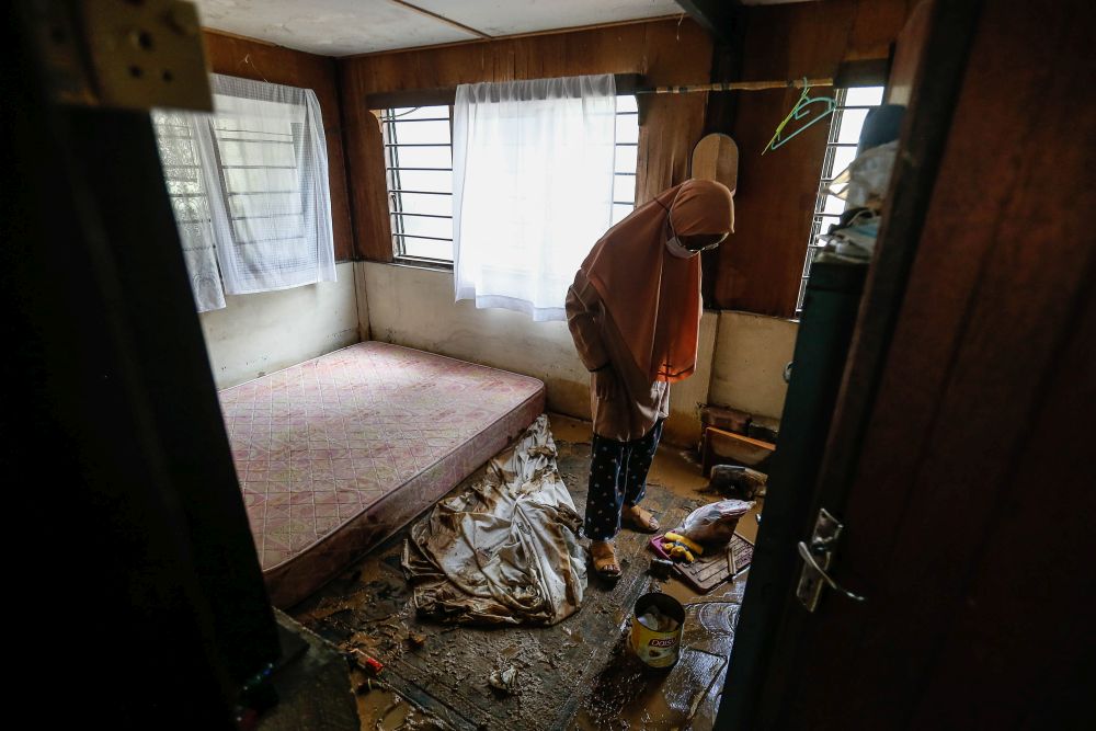 Ku Masturah Ku Abdullah inspects her belongings at home following flash floods in Yan August 25, 2021. u00e2u20acu201d Picture by Sayuti Zainudin