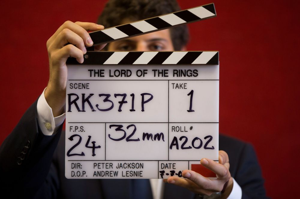 A gallery assistant poses for a photograph with a clapper board used in the filming of the Lord of the Rings film u00e2u20acu02dcReturn of the Kingu00e2u20acu2122 in Bonhams auction house in London July 31, 2014. u00e2u20acu2022 Reuters pic