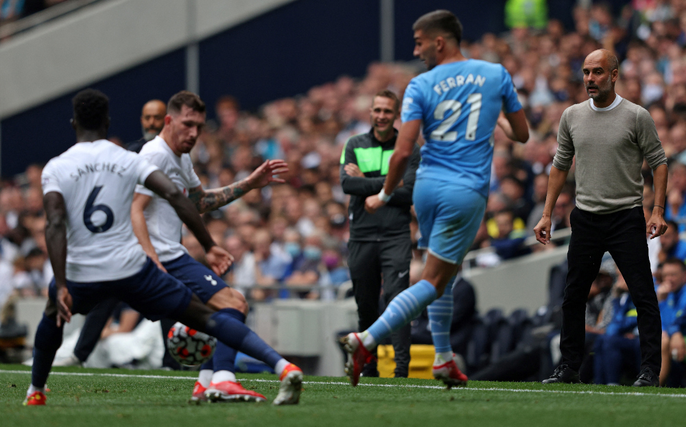 Manchester City manager Pep Guardiola watches as midfielder Ferran Torres passes the ball past Tottenham Hotspuru00e2u20acu2122s defender Davinson Sanchez at Tottenham Hotspur Stadium in London, August 15, 2021. u00e2u20acu201d AFP pic 